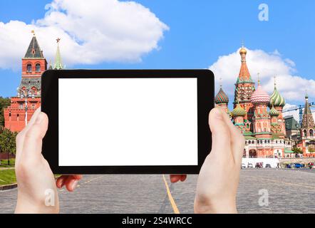 Travel Concept - Hand hält tablet pc mit ausgeschnittenen und Vasilevsky Abstieg auf dem Roten Platz mit Pokrovsky Cathedral auf Hintergrund Stockfoto