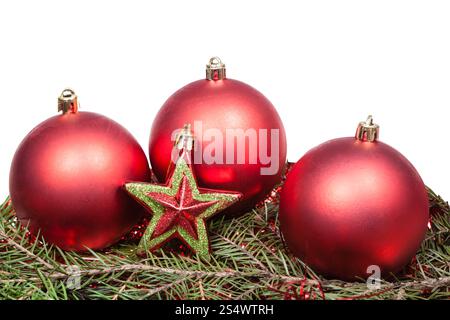 rote Sterne und rote Christbaumkugeln auf grüne Firtree Zweig auf weißem Hintergrund isoliert Stockfoto