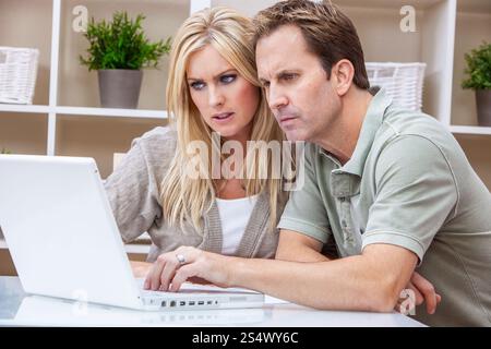Besorgte junge Mann und Frau Paar mit Laptop-Computer zu Hause, Internet und Konzept der Lebenshaltungskosten Stockfoto