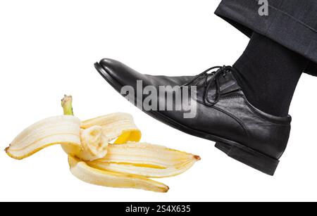 männliche Bein in die linken schwarzen Schuh rutscht auf einer Bananenschale isoliert auf weißem Hintergrund Stockfoto