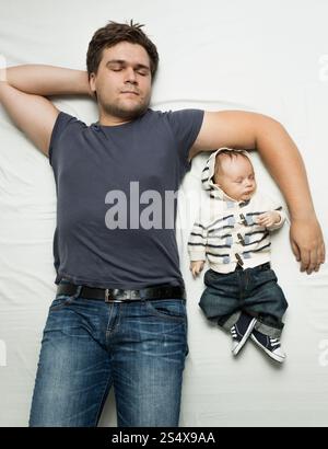 Draufsicht Porträt des stilvollen Vater und Baby Boy auf Bett schlafen Stockfoto