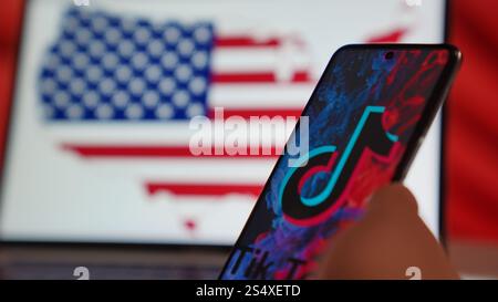 Foto des TikTok Bans in den USA: Telefon mit der TikTok App und Laptop mit der US-Flaggenkarte, die digitale Einschränkungen symbolisiert. Amerika verbietet TikTok. Stockfoto