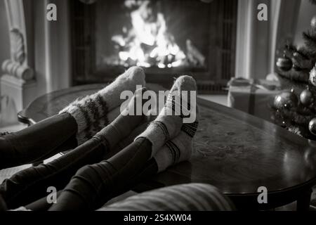 Black And White Nahaufnahme Bild der Familie in wollene Socken ruht am brennenden Kamin Stockfoto