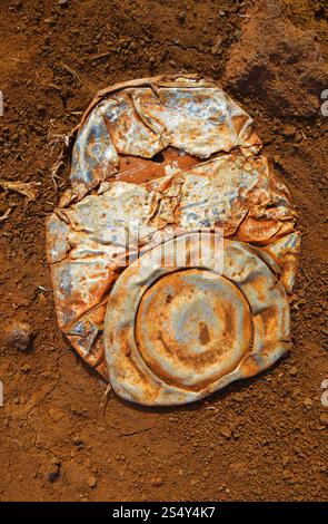 Alte zerquetschte, rostige Dose auf staubigem Hintergrund . Alte, zerquetschte, rostige Dose Stockfoto