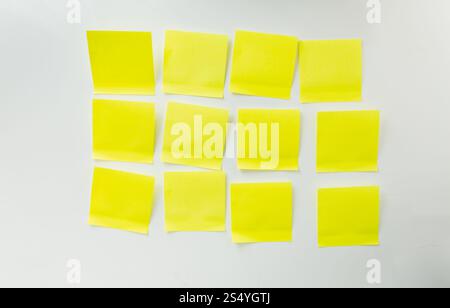12 leere gelbe Haftnotizen auf Whiteboard Stockfoto