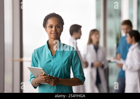 Afrikanische Ärztin mit Peeling posiert in der Klinik mit Tablette Stockfoto