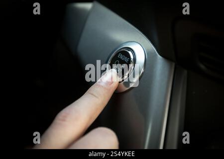 Nahaufnahme des Fahrers startet den Motor durch Drücken der Taste Stockfoto