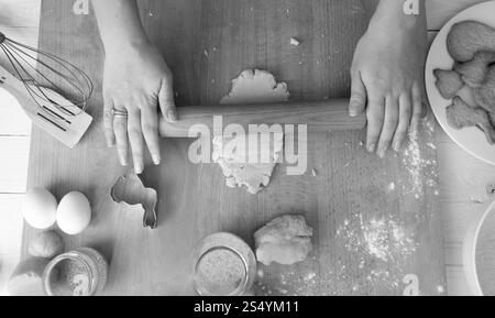 Schwarz-weiß-Bild von oben über Frau, die Teig für Weihnachtskekse zubereitet Stockfoto