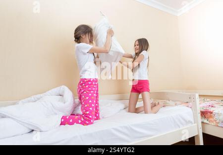 Zwei Mädchen im Schlafanzug kämpfen mit Kissen Stockfoto