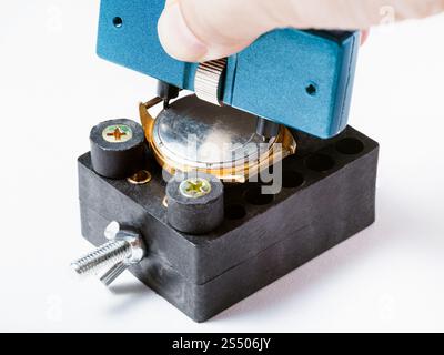 Uhrmacher Workshop - Öffnen der rückwärtigen Abdeckung des alte Uhr in der Halterung mit verstellbarem Stiftschlüssel feste auf weißem Hintergrund Stockfoto