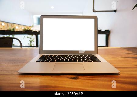 Laptop mit Mock up leeren Bildschirm auf holztisch vor Coffeeshop Café Platz für Text. Produkt anzeigen Montage-Konzept. Stockfoto