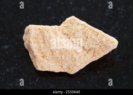 Makroaufnahmen von natürlichen Mineralgestein Muster - grobe Sandstein Stein auf dunklem Granit Hintergrund Stockfoto