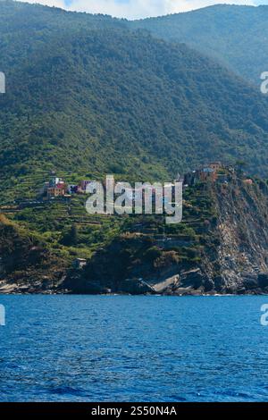 Wunderschöner Blick auf Corniglia im Sommer vom Ausflugsschiff. Eines von fünf berühmten Dörfern des Cinque Terre Nationalparks in Ligurien, Italien, zwischen Stockfoto