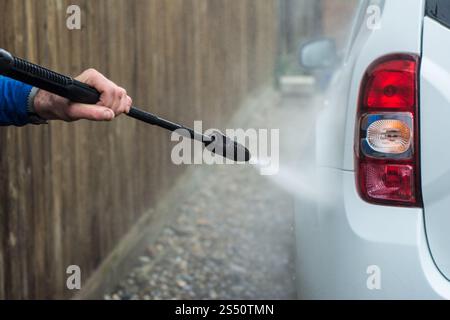 Nahaufnahme eines Mannes Hände waschen sein Auto mit einem großen Kopf Wasser von einem karcher im Freien. Reinigung und Desinfektion. Sicherheitsmaßnahmen durin Stockfoto