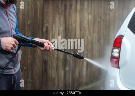 Nahaufnahme eines Mannes Hände waschen sein Auto mit einem großen Kopf Wasser von einem karcher im Freien. Reinigung und Desinfektion. Sicherheitsmaßnahmen durin Stockfoto