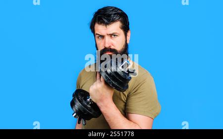 Starkes Manntraining mit Kurzhanteln im Sportclub. Gesunder Lebensstil und Kraftübungen. Bärtiger Mann, der Hantel hebt und Gewichtheben macht. Sportler Stockfoto