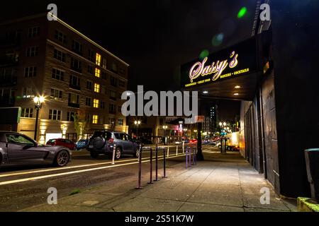 City Street at Night mit beleuchteten Shopschildern und vorbeifahrenden Autos, Portland, Oregon Stockfoto