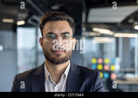 Nahaufnahme eines erfolgreichen selbstbewussten Geschäftsmannes, eines Mannes im Business-Anzug, der in die Kamera blickt, eines Investors am Arbeitsplatz im Büro. Stockfoto