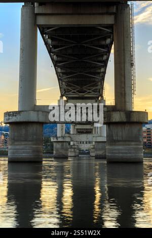 Unter einer Marquam Bridge, die über einen ruhigen Willamette River Waterway bei Sunset, Portland, Oregon, überspannt Stockfoto