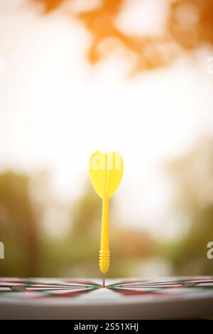 Gelbe dart Pfeil schlagen in der Mitte der Dartscheibe. Stockfoto