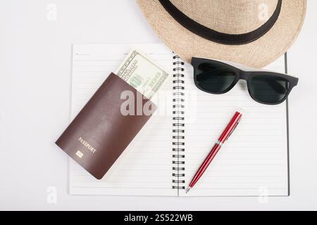 Pässe, Hut, Kamera, Brille, Stift auf einem Papierboden bereit zum tr. Pässe, Hut, Kamera, Brille, Stift auf einem Papierboden bereit für die Reise. Stockfoto