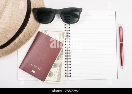 Pässe, Hut, Kamera, Brille, Stift auf einem Papierboden bereit zum tr. Pässe, Hut, Kamera, Brille, Stift auf einem Papierboden bereit für die Reise. Stockfoto