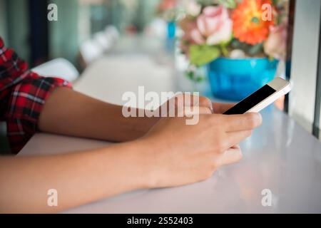 Nahaufnahme von Frauenhänden, die Handy halten und tippen. Stockfoto