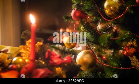 Perfektes Foto für Winterferien und Feierlichkeiten mit Weihnachtsbaum vor Kamin und Kerzen. Perfektes Image für den Winterurlaub und Stockfoto
