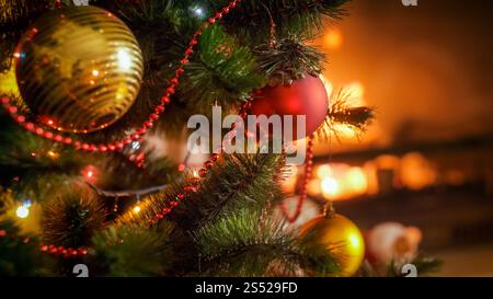 Perfektes Foto für Winterfeiern mit Weihnachtsbaum vor brennendem Kamin im Haus. Perfektes Image für Winterfeiern mit Weihnachten Stockfoto