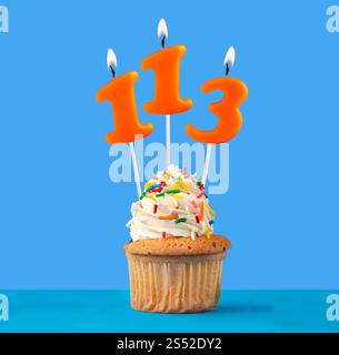 Orange Geburtstagskerze und Cupcake - Nummer 113. Stockfoto