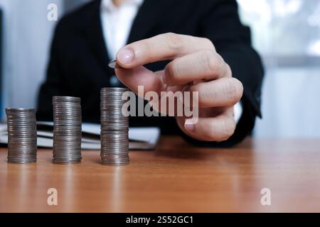 Buchhalter das Geschäft prüfen und Geld sparen stapeln Goldmünzen mit Taschenrechner. Buchhaltung Konzept. Stockfoto