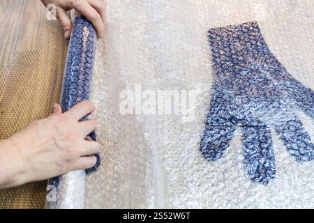 Werkstatt von Hand eine Fleece Handschuhe von blau Merino Schafschurwolle nass Filzen Prozess - Handwerker Brötchen gefilzte Handschuhe in Matte für Walken Stockfoto
