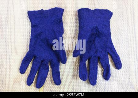Werkstatt von Hand eine Fleece Handschuhe von blau Merino Schafschurwolle nass Filzen Prozess - fertig Nass gefilzt Handschuhe auf mat Stockfoto