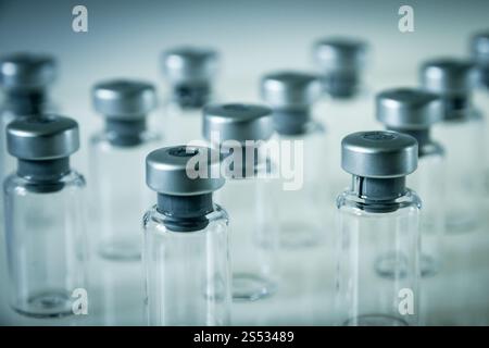 Gruppe von Impfglasflaschen auf grauem Hintergrund. Impfglasflaschen auf grauem Hintergrund Stockfoto