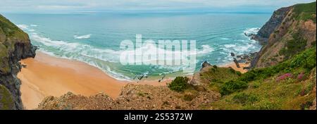 Sandstrand mit felsigen Bergrücken trübes Wetter Aussicht auf Sommer Atlantic an der felsigen Küste (Costa Vicentina, Algarve, Portugal). Und Ocean Surf Wellen. Stockfoto
