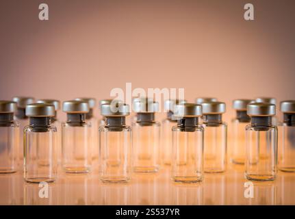 Gruppe von Impfglasflaschen auf orangem Hintergrund. Impfglasflaschen auf orangem Hintergrund Stockfoto