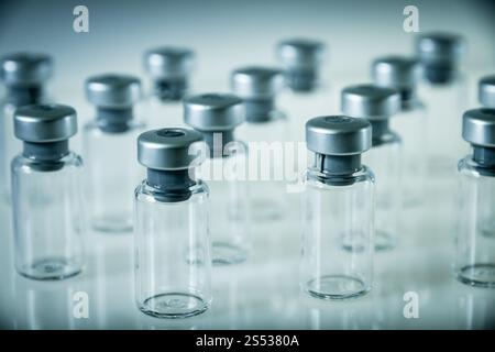 Gruppe von Impfglasflaschen auf grauem Hintergrund. Impfglasflaschen auf grauem Hintergrund Stockfoto