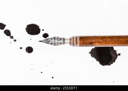 Blick von oben auf die braunen Dip Pen und schwarze Tinte Flecken auf weißem Papier Stockfoto