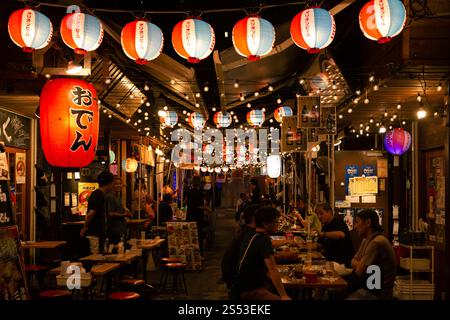 Kleine Straße mit vielen Straßenbars (Izakaza) in der Nacht mit Lampen in Naha Okinawa, Kokusai dori dekoriert Stockfoto