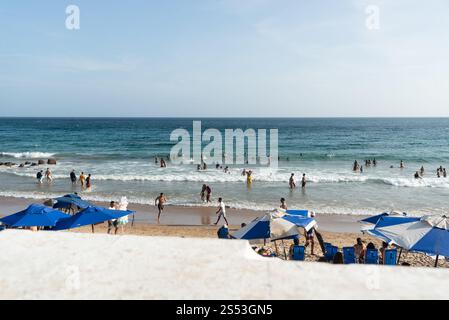 Salvador, Bahia, Brasilien - 5. Januar 2025: Am Strand von Farol da Barra werden Menschenmassen beobachtet, die Spaß haben und im Meer baden. Salvador, Bahia. Stockfoto