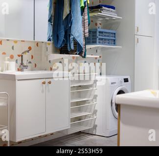 Das Innere des Waschbades ist mit Waschmaschinen und Kleidung ausgestattet Stockfoto