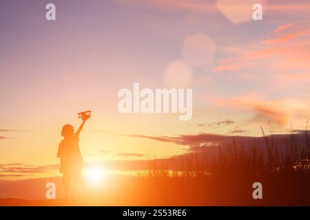 Silhouette Junge spielt mit Spielzeug Flugzeug Sonnenuntergang Stockfoto