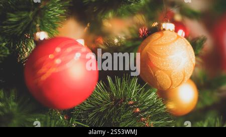 Nahaufnahme-Bild von Nadeln und bunten Kugeln auf dem Weihnachtsbaum. Perfekter Hintergrund für Winterferien und Feierlichkeiten. Nahaufnahme getöntes Foto Stockfoto