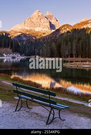 Bank in der Nähe des Herbstabendsees Misurina und der drei Zinnen des Lavaredo (drei Zinnen von Lavaredo), Dolomiten, Italien. Menschen sind nicht erkennbar. Malerisch Stockfoto