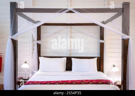 Himmelbett mit weißem Moskitonetz. Urlaub oder Urlaub im tropischen Klimakonzept. Stockfoto