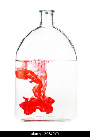 Rote Tinte löst sich in Wasser in der Flasche auf weißem Hintergrund. Rote Tinte löst sich in Wasser in der isolierten Flasche auf Stockfoto