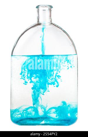 Blaues Aquarell löst sich in Wasser in einem Glaskolben auf weißem Hintergrund auf. Blaues Aquarell löst sich in Wasser im Glaskolben auf Stockfoto