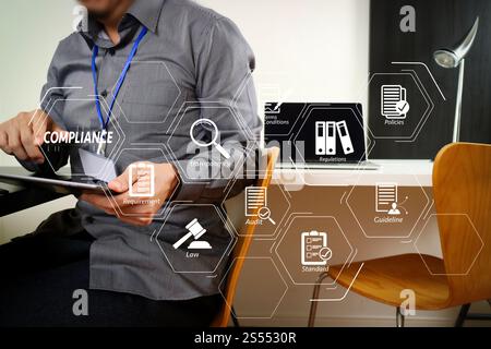 Compliance virtuelles Diagramm für Vorschriften, Gesetze, Standards, Anforderungen und Audits. Geschäftsmann, der mit einem digitalen Tablet und einem Laptop arbeitet, und Stockfoto