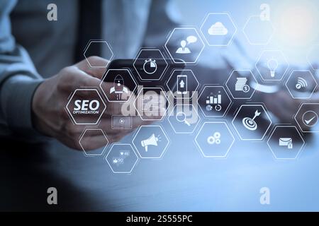 SEO-Optimierung für Website mit mobiler Website und Landing-Page virtuelles Diagramm. Von Geschäftsmann, der mit Handy und Brille auf Holz arbeitet Stockfoto