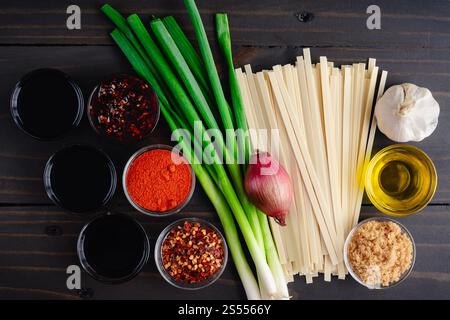 Schalotten Chili Oil Noodles Zutaten auf einem Holztisch: Rohe lo meine Nudeln, grüne Zwiebeln, Gochugaru und mehr für heiße und scharfe asiatische Fusionspusta Stockfoto